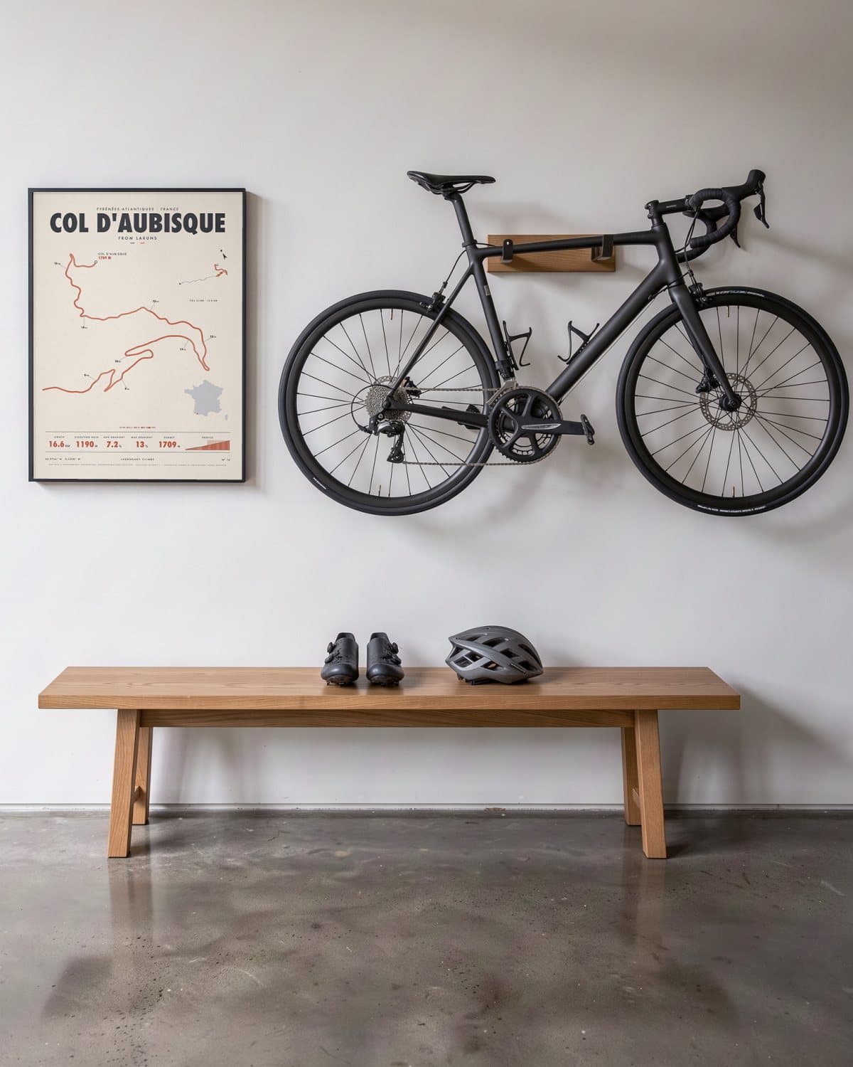 Col d'Aubisque cycling climb poster in a black frame (45 × 60 cm) in a hallway beside a road bike