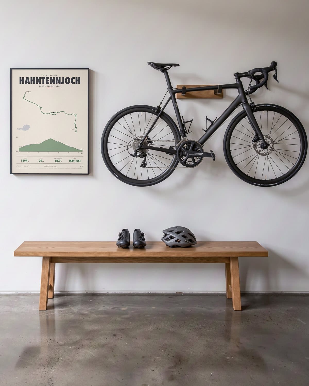 Hahntennjoch mountain pass poster in a black frame (45 × 60 cm) in a hallway beside a road bike