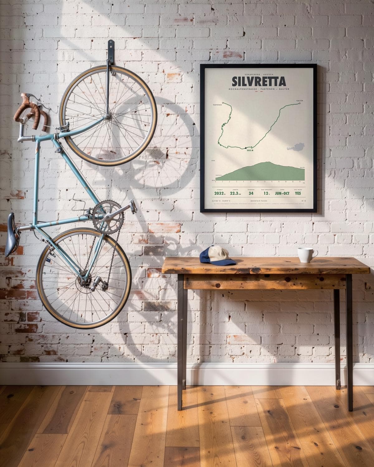 Silvretta mountain pass poster in a black frame (45 × 60 cm) in a brick loft with a vintage bike