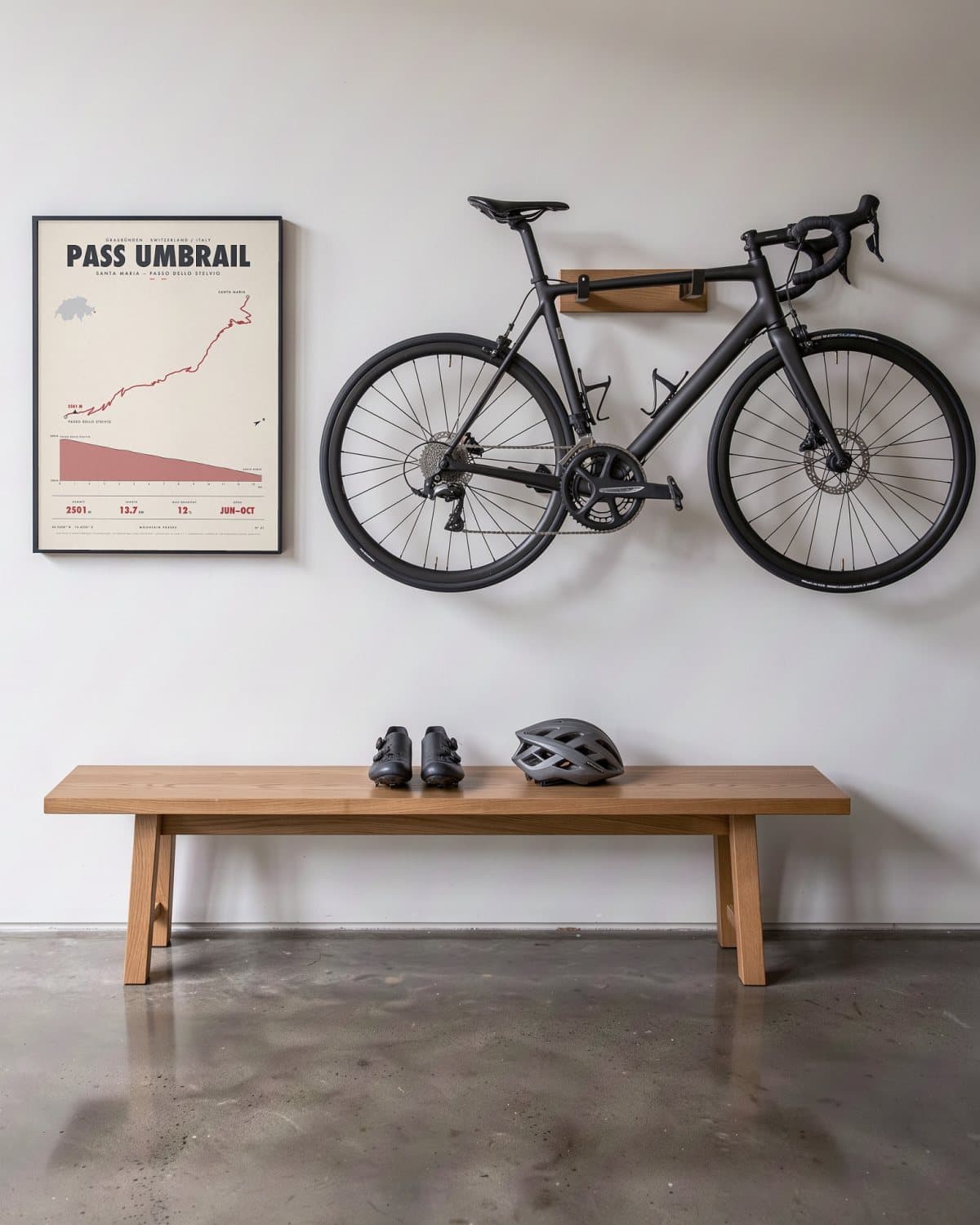 Pass Umbrail bergpasposter in een zwarte lijst (45 × 60 cm) in een hal naast een racefiets