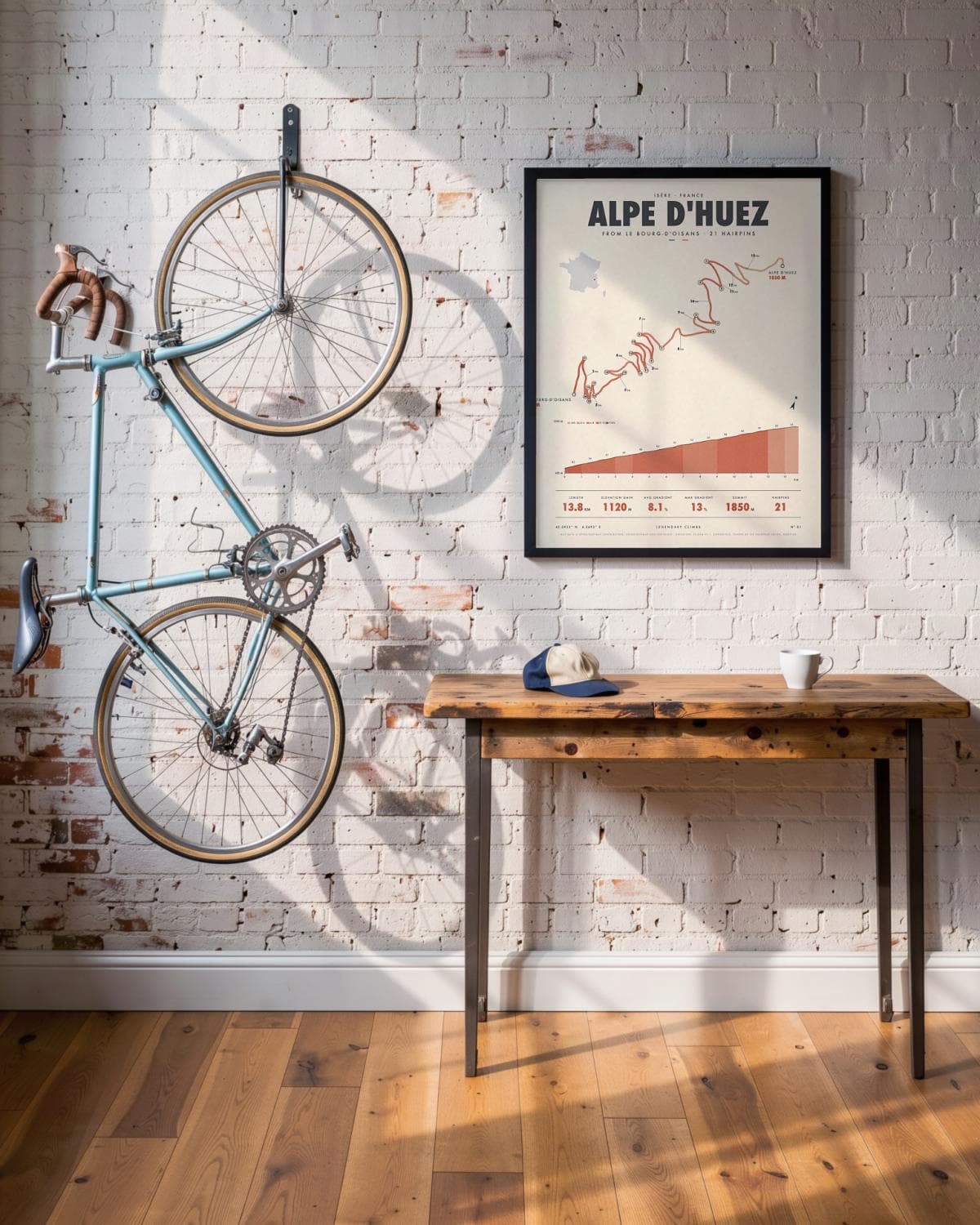 Alpe d'Huez cycling climb poster in a black frame (45 × 60 cm) in a brick loft with a vintage bike