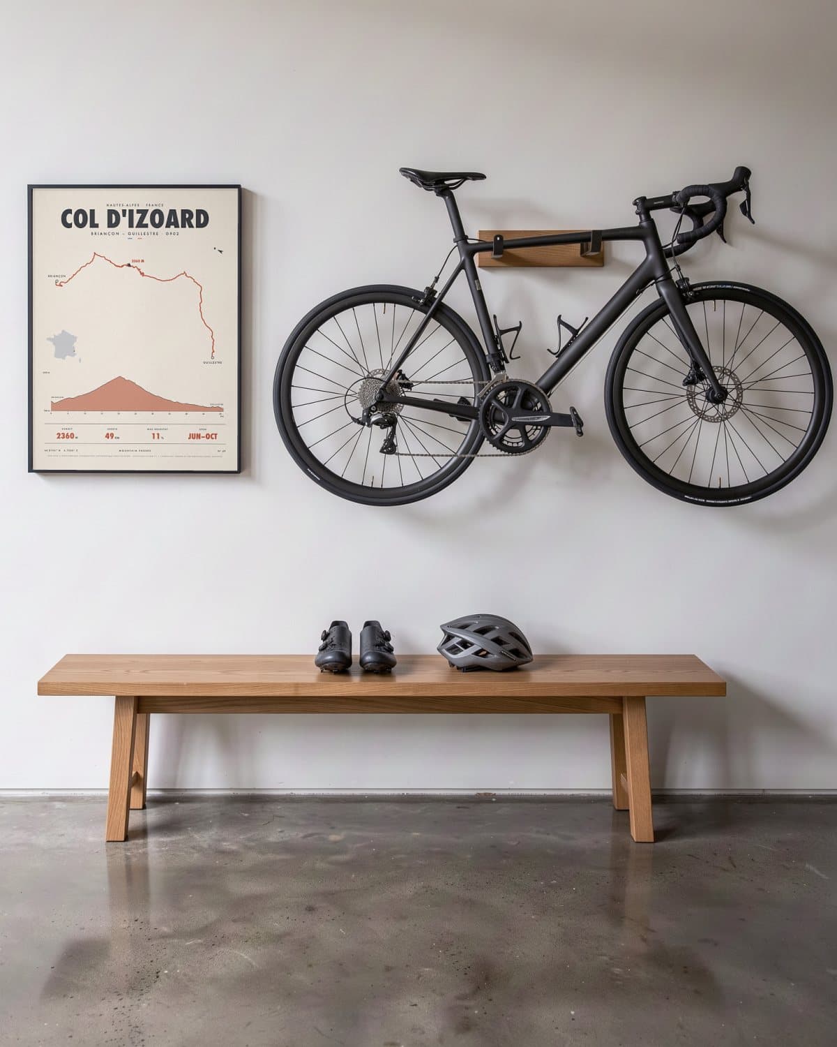Col d'Izoard mountain pass poster in a black frame (45 × 60 cm) in a hallway beside a road bike
